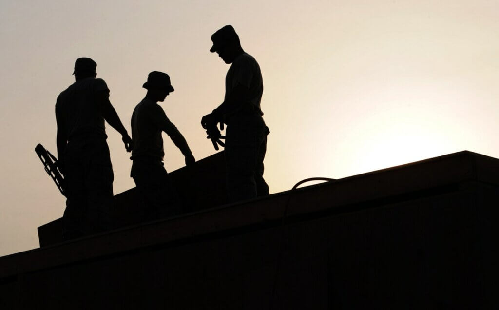 workers working in front of a bright sky