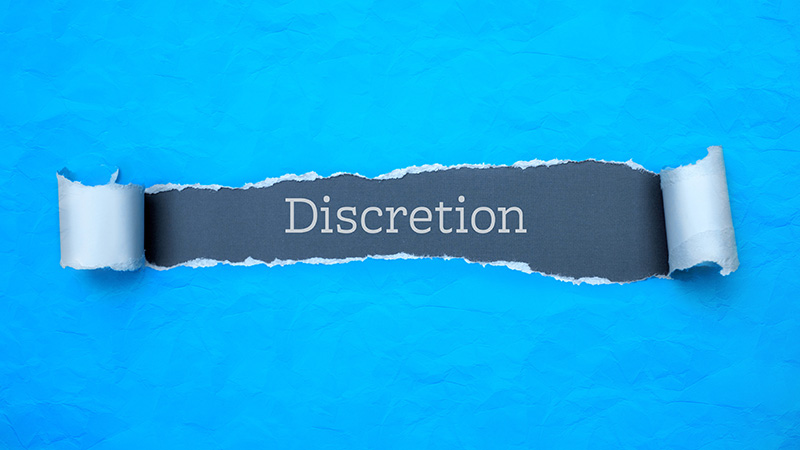 stealth wealth Discretion. Blue torn paper banner with text label. Word in gray
